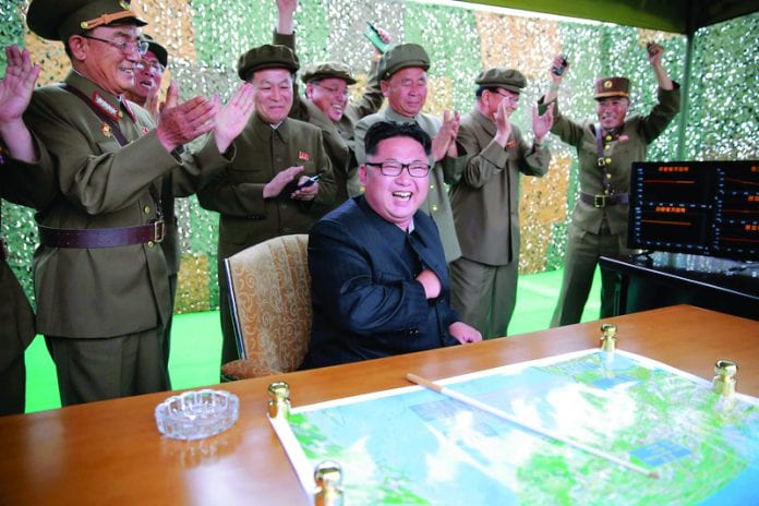 FILE PHOTO: North Korean leader Kim Jong Un reacts during a test launch of ground-to-ground medium long-range ballistic rocket Hwasong-10