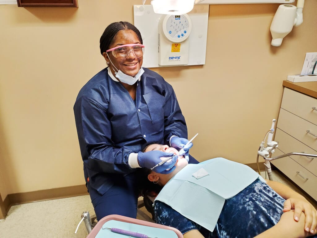 Dental Hygienist Shamiah Ferguson assisting with dental needs for back to school. The