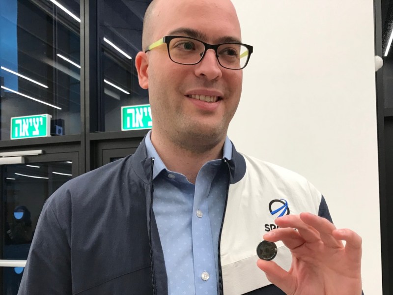 SpaceIL co-founder Yonatan Winetraub, National Institutes of Health award winner, displaying a copy of the coin-size nano Bible in the time capsule aboard Beresheet. (Abigail Klein Leichman)