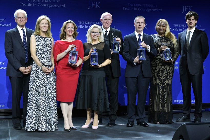 The 2022 John F. Kennedy Profile in Courage Award recipients, holding their awards, from left: Michigan Secretary of State Jocelyn Benson; US Representative Liz Cheney; US Representative Russell "Rusty" Bowers; Yaroslav Brisiuck, deputy chief of mission at the Embassy of Ukraine, accepting on behalf of Ukrainian President Volodymyr Zelensky; and Wandrea’ ArShaye Moss, a former Fulton County, Ga., election worker. They were flanked by, from left, Ed Schlossberg, his wife, Ambassador Caroline Kennedy, and son Jack Schlossberg on Sunday at the John F. Kennedy Presidential Library and Museum in Boston.JOSH REYNOLDS/ASSOCIATED PRESS