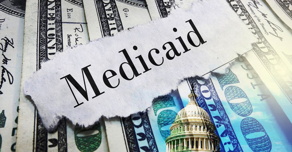 Medicaid newspaper headline on hundred dollar bills with US Capitol in Washington DC