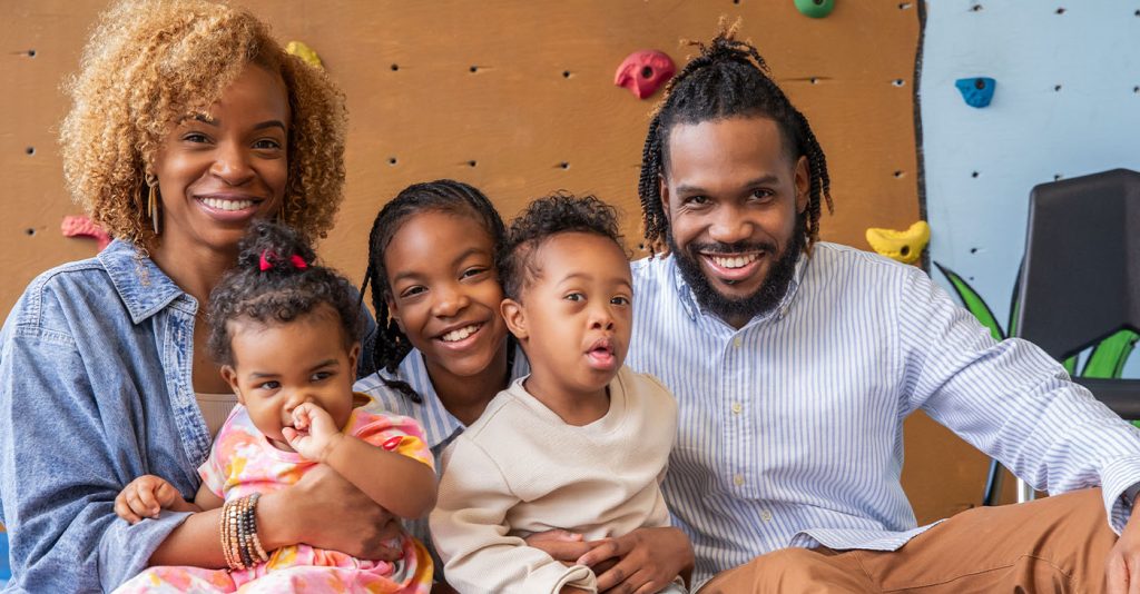 Little boy with Down Syndrome with his parents and sisters ( Photo by Courtney Hale)