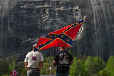 The Sons of the Confederate Veterans hold flags and celebrate at their annual Memorial Day at Stone Mountain Park on April 19, 2025 in Stone Mountain, Georgia. Stone Mountain has a 190 ft long Confederate Memorial engraved on one face of the large granite mountain completed in 1972. (Photo by Megan Varner/Getty Images)