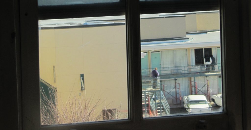 View of Lorraine Hotel, from second floor bathroom window in the boarding house from where James Earl Ray was alleged to have fired the fatal shot at Martin Luther King, Jr., Boarding house view of Lorraine Motel balcony. Photo: Mr. Littlehand / Wikimedia Commons.