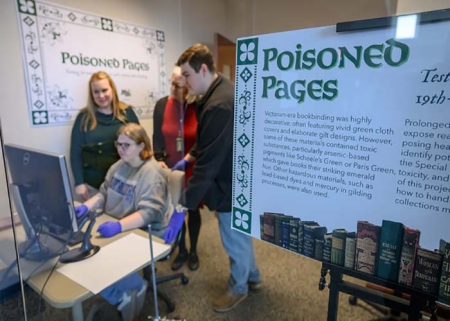 Chemistry instructor Sarah Pierce, standing at left, Special Collections librarian Susan Martin, center, and chemistry graduate student Ethan Coyle look over the shoulders of forensic science student Brittney Cupp as they examine incoming data from the X-ray fluorescence spectroscopy, or XRF, set up in the Special Collections at Middle Tennessee State University’s James E. Walker Library in Murfreesboro, Tenn. The machine is used to identify and quantify toxic compounds and heavy metals found in the pigments used in many 19th-century books housed in the university’s Special Collections. The “Poisoned Pages” project was made possible through a University Research and Creative Activity, or URECA, grant that bolstered the collaboration between the Department of Chemistry and the library. (MTSU photo by J. Intintoli)